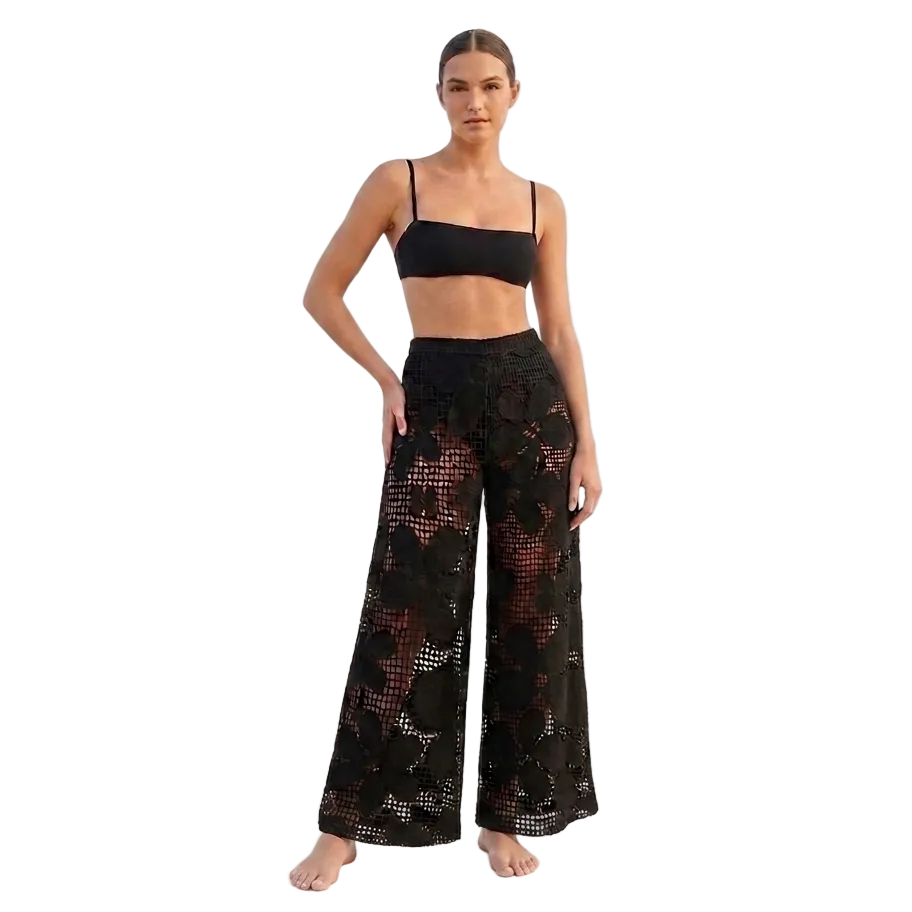 Woman wearing a black lace top and wide-leg pants 